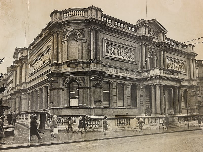 Shoppers and pedestrians wrapped in warm coats stroll past the main entrance of Wolverhampton Art Gallery in January 1969. The striking grand stone building on Lichfield Street, renowned for its ornate classical stonework and friezes, provided a cultural focal point for the town during the winter months. Festive lights can still be seen strung up across the street outside the entrance, reflecting a peaceful start to the new year in Wolverhampton town centre. Do you remember visiting Wolverhampton Art Gallery in the 1960s or taking shelter from the winter weather inside its grand halls?