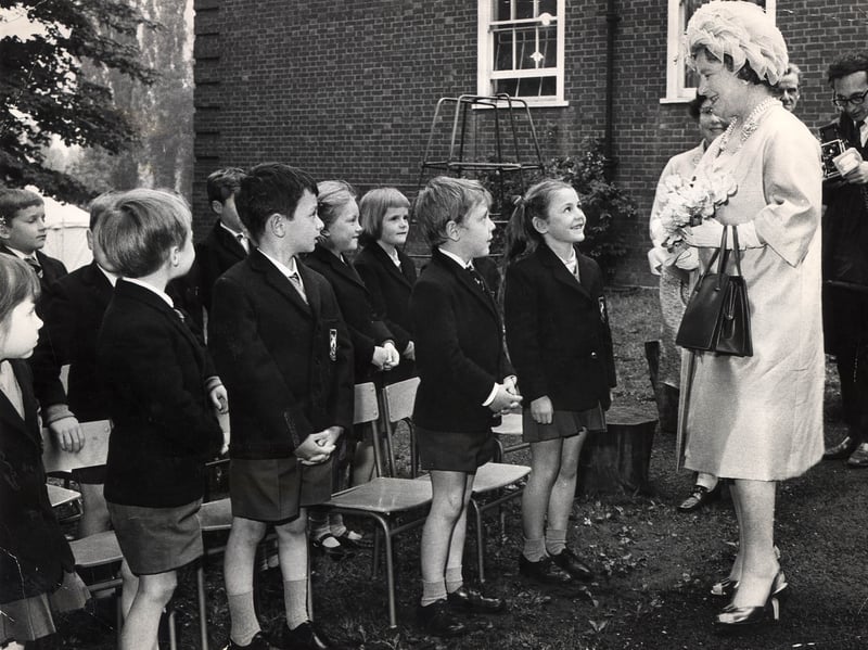 Queen Elizabeth The Queen Mother smiles warmly as she greets a lined-up row of young schoolchildren during a memorable visit to The Royal School, Wolverhampton, in June 1969. Dressed in smart blazers and shorts, the pupils stood proudly outside the school grounds as the royal guest paused to speak with them while holding a posy of flowers. The visit was a standout moment of royal glamour for the town that summer, creating a cherished memory for all the staff and children involved. Were you among the lucky pupils who lined up to meet the Queen Mother at The Royal School in Wolverhampton in 1969?
