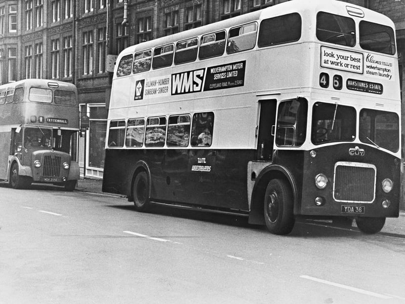 A double-decker Guy bus operating the No. 46 route to Warstones estate stops along the street in October 1969, boasting prominent side advertisements for Wolverhampton Motor Services Limited and Wolverhampton Steam Laundry. Following the takeover of the local transport department by the West Midlands Passenger Transport Authority, the town's familiar green buses were set for a major makeover, gradually repainted into the new Oxford blue and cream livery. The transition marked a significant milestone in modernising public transport services across Wolverhampton. Do you remember riding the No. 46 bus or seeing the old livery change across Wolverhampton in late 1969?