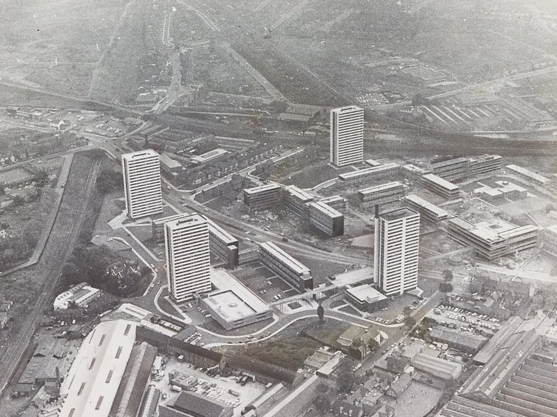 A striking aerial perspective captures the vast scale of the multi-million-pound Heath Town housing development in October 1969. Dominating the landscape are four newly constructed multi-storey residential tower blocks, intersected by Wednesfield Road as it cuts through towards its junction with Tudor Road and Deans Road. Surrounding industrial landmarks frame the modern estate, including the Chubb lock factory visible to the bottom right and the former Culwell Works to the bottom left, then being redeveloped into a modern industrial estate. The dramatic photograph highlights the ambitious post-war urban renewal efforts reshaping social housing across Wolverhampton. Do you remember watching the Heath Town estate being built or living in one of these iconic tower blocks during the late 1960s?