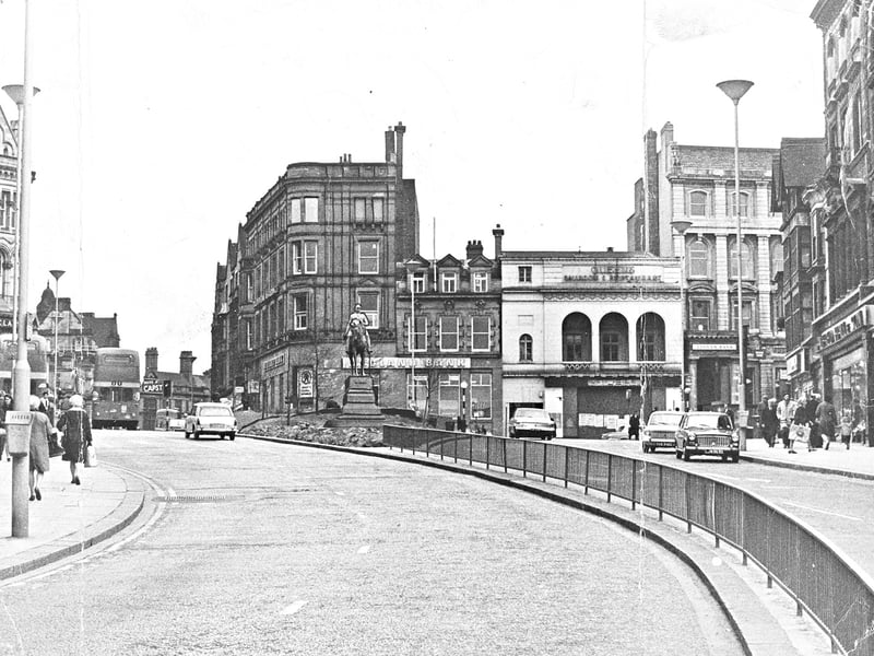Traffic and pedestrians navigate Queen Square in March 1969, with the iconic equestrian statue of Prince Albert standing proudly at the centre. Looking down towards the square, historic Victorian facades house local branches of Midland Bank and Lloyds Bank alongside popular dining establishments like Queen's Ballroom & Restaurant. Safety railings and newly configured roadways highlight how the heart of Wolverhampton adapted to accommodate growing motor traffic while preserving its celebrated 19th-century architecture. Do you remember visiting Queen Square or going to the Queen's Ballroom back in 1969?