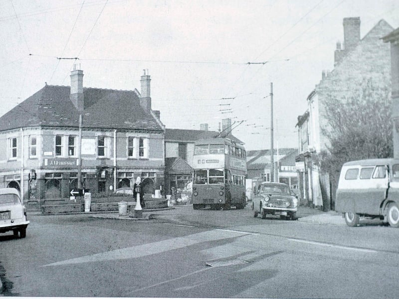 The Staffordshire Knot public house stands prominently on the corner of Wolverhampton Street and Pinfold Street at Catherine's Cross, Darlaston, in November 1963. A double-decker trolleybus navigates the junction beneath the web of overhead power cables, framed by classic 1960s saloons and a delivery van. Serving Atkinsons ales to local foundry workers and residents, the pub was a familiar Black Country landmark in an era when electric transport still dominated the streetscape. Do you remember popping into the Staffordshire Knot for a tipple or passing through Catherine's Cross back in the sixties?