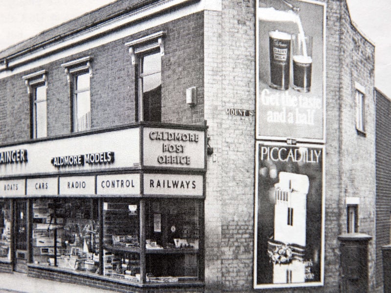 S. H. Grainger’s famous Caldmore Models store stands proudly on the corner of Mount Street, complete with the local post office sign above the window. Packed to the rafters with model railways, radio control kits, aircraft, boats, and cars, the shop was an absolute treasure trove for local enthusiasts and pocket-money collectors alike. Vintage advertising hoardings on the side wall complete the nostalgic street scene, capturing a beloved corner shop that drew hobbyists from all across Walsall. Did you ever spend your pocket money on Airfix kits or model railways at Grainger's shop?