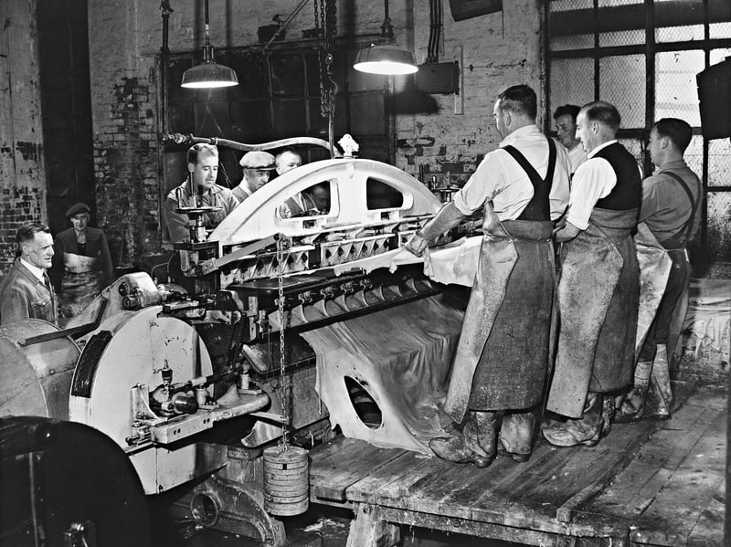Skilled tanners feed heavy cowhides through a massive splitting machine at a Walsall leatherworks in May 1962. Dressed in protective aprons and heavy boots, the workforce carefully manages the delicate, highly precise process that slices thick hides into uniform sheets ready for finishing. As the heart of the nation’s saddlery, harness, and fine leather goods trade, Walsall’s tanneries relied on the master craftsmanship and expertise of local workers to supply high-grade materials across the globe. Did you or anyone in your family work in the famous Walsall leather trade back in the day?