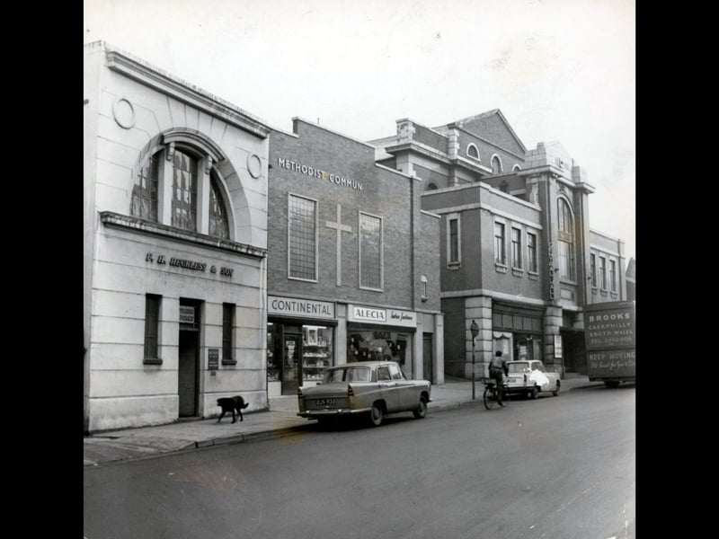 The new Methodist community hall nears completion along Ablewell Street in Walsall in January 1961, standing alongside Central Hall and neighbouring businesses such as F. H. Reckless & Son and Alecia ladies' fashions. Featuring a prominent brick cross flanked by large multi-pane windows and modern storefronts, the fresh development provided a welcoming hub for local church groups and social gatherings. The street scene offers a wonderful snapshot of early 1960s town life, complete with classic cars parked along the curb and a passing cyclist. Do you remember attending social events or youth clubs at the Methodist community hall in Ablewell Street?