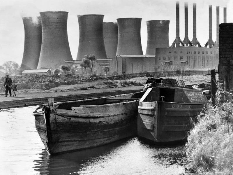Traditional wooden canal narrowboats sit moored along the towpath as the imposing cooling towers and chimneys of Walsall Power Station dominate the background in October 1964. Captured from the banks of the canal near Bloxwich, the dramatic scene perfectly illustrates the blend of classic Black Country waterways and heavy industrial power generation that defined the local landscape. Generating electricity for surrounding towns and factories throughout the post-war era, the massive station was one of the borough's most unmistakable landmarks until its eventual closure and demolition. Do you remember watching the steam rise from the giant cooling towers when walking along the canal?
