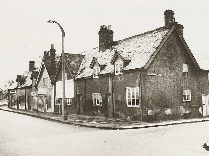 Characterful old cottages standing at the junction of High Street and Rookery Lane in Aldridge during the 1960s, with St Mary's Church tower just visible in the distance. Featuring gabled roofs, dormer windows, and prominent brick chimneys, these traditional buildings captured the village-like charm of the area before post-war redevelopment swept through. Sadly demolished later to make way for modern road layouts and commercial improvements, the scene preserves a fondly remembered piece of Aldridge’s architectural heritage. Do you remember these picturesque cottages standing at the corner of Rookery Lane before the street was transformed?