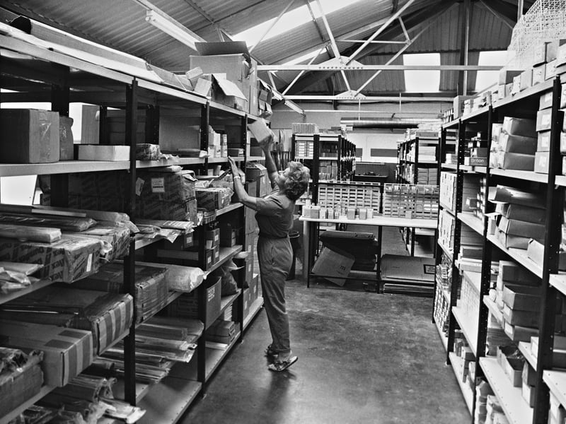 A worker reaches for stock high on the neatly organised shelving units inside a bustling commercial warehouse in August 1990. Celebrating a quarter-century of steady expansion, local firm Harper & Beardmore Ltd marked the milestone with a major re-launch to offer an even broader range of services, moving operations into expanded, modernised premises to keep pace with demand. Did you ever work in stock control or warehouse distribution during the industrial boom of the 1990s?