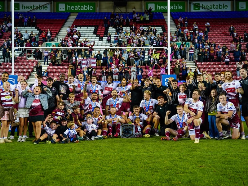 Wigan Warriors players and family celebrate the League Leaders' Shield in front of the South Stand