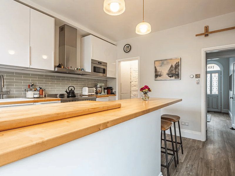 The kitchen features access to the cellar for extra storage and hobby space.