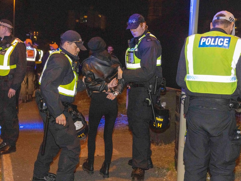 A person is led away by police during a protest in Gosport, after police closed off the access road to Haslar Marina, after British rescue boats have been sent to collect the passengers of a migrant dinghy which has spent around 30 hours at sea. Photo: Trevor Adams/PA Wire