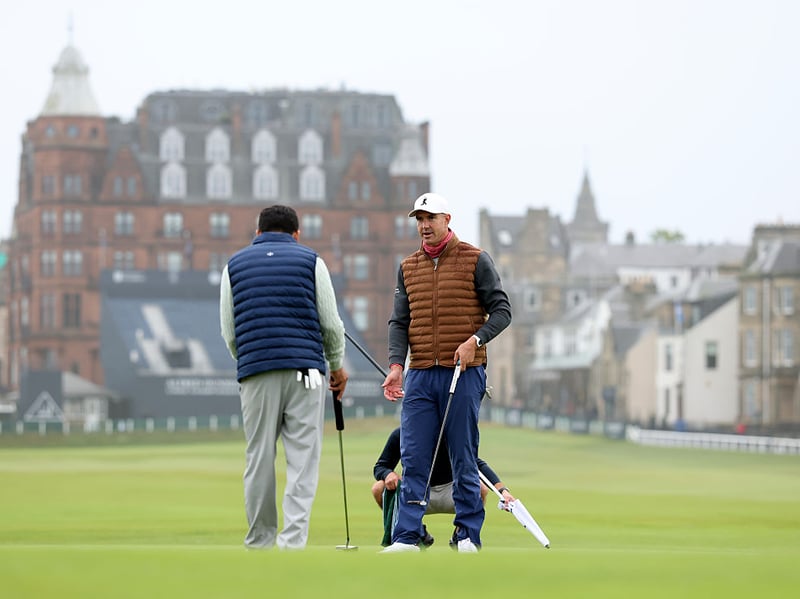Former Cricketer Kevin Pietersen talks to his partner during their Old Course practice round.