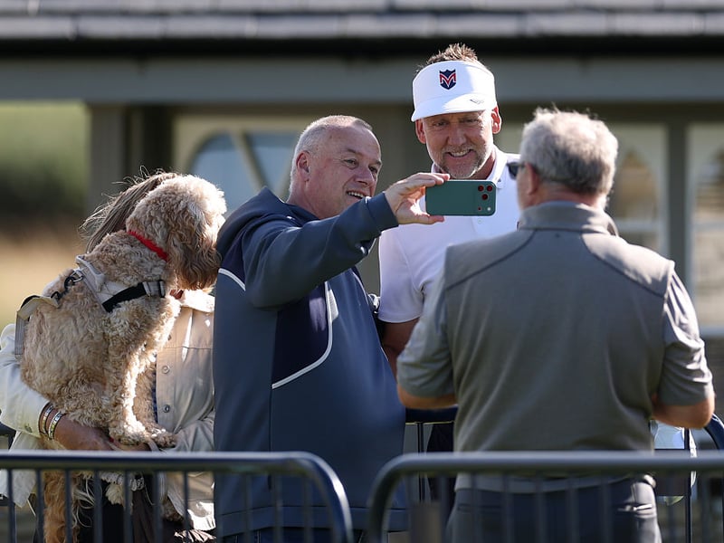Ian Poulter takes selfies with fans during his practice round.