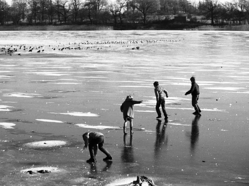 Dusk catches children playing on a frozen Duddingston Loch in Edinburgh, iced over during the cold weather in February 1985.