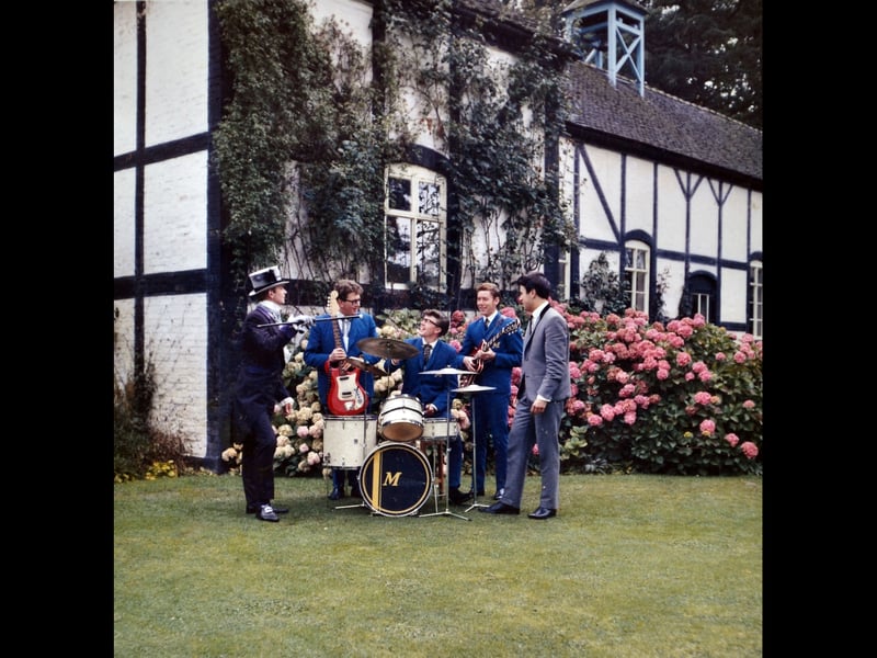 Wow, a publicity shot in colour. That's classy. These are The Midnighters, and they are by the tea rooms of Hodnet Hall Gardens around the mid-1960s. The Midnighters were a Market Drayton beat group. Left is vocalist Malcolm Davison, who apparently went as Screaming Lord Strongbow. Second left is Ted Orwell, lead guitar, drummer is Roy Bickley, then comes Arthur Preece who was rhythm guitar, and right is John Edwards, who played bass guitar. Missing is vocalist Alan Palmer, who worked for the council and apparently couldn't get time off work for this photoshoot.
