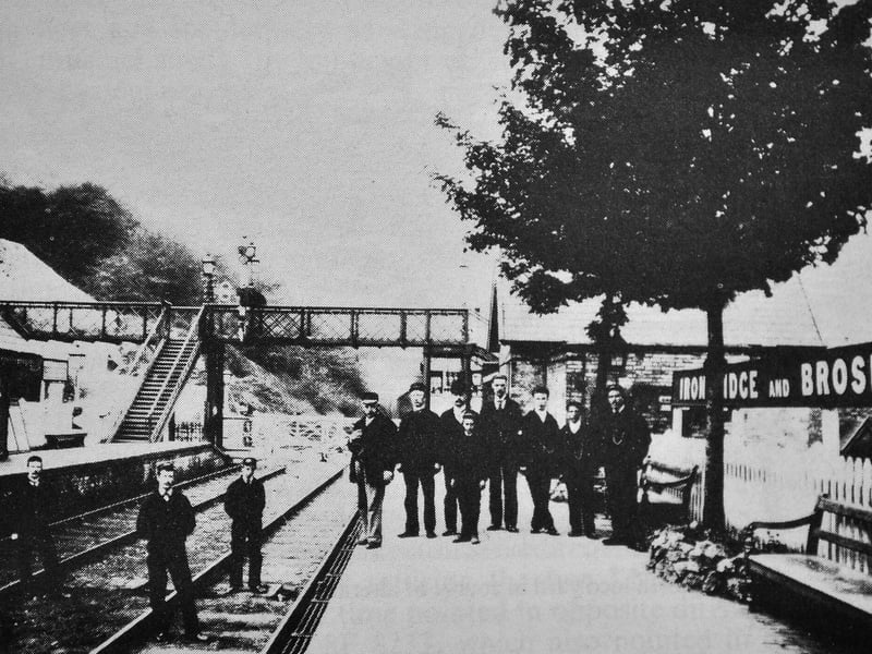 Ironbridge Railway Station in 1897, or, to be precise, Ironbridge and Broseley Railway Station, as can be seen by the sign, which Keith said was the longest name board on the Severn Valley Railway at the time. The original of this photo once hung in one of the station rooms. It shows the staff posing by the new nameboard which was changed from simply "Ironbridge" to "Ironbridge and Broseley" on November 9, 1895. It was replaced some time later by a rectangular board.