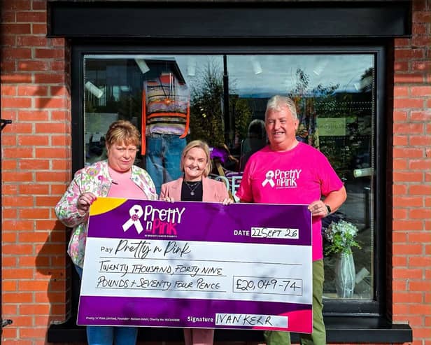 Ivan and Sylvia Kerr pictured outside Storey Menswear, Linen Green, with their cheque for £20,049.74. 