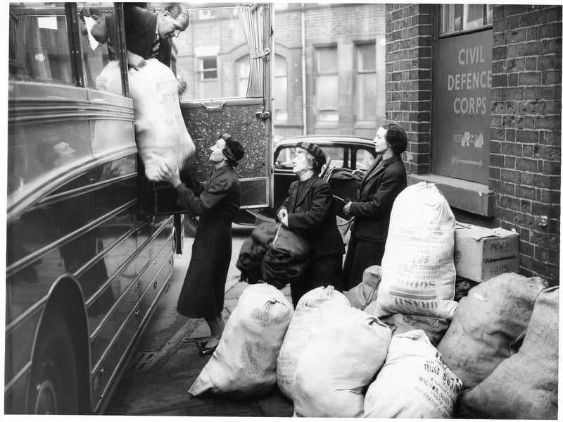 Three WVS members load sacks of clothing and items for refugees from Hungary into a bus in Sheffield in 1956