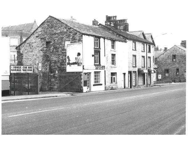 A photograph taken of the fronts of the houses and shops on Church Street, opposite the Old Grammar School, in 1988.