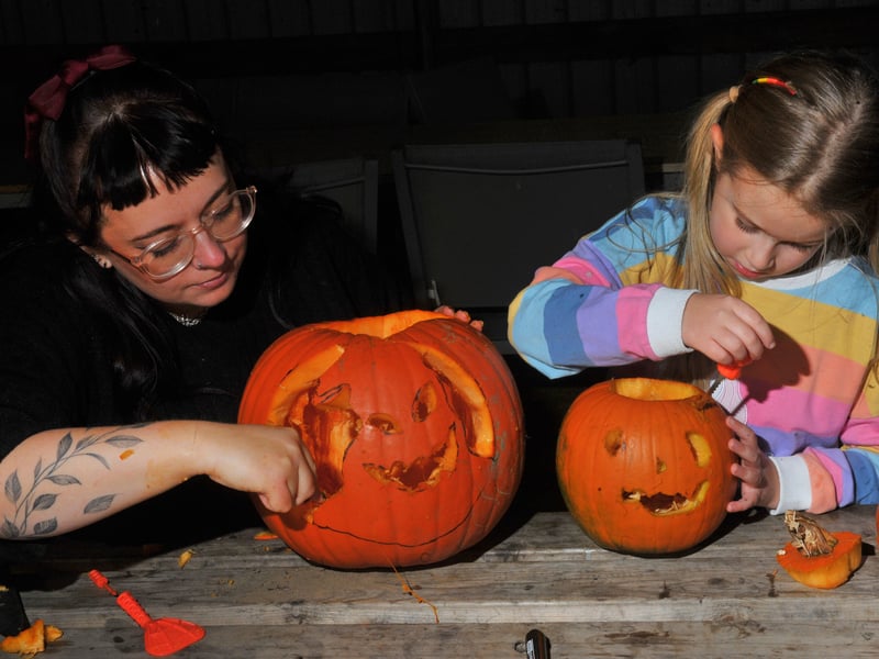 Laura and Ellie Hastings carving pumpkins