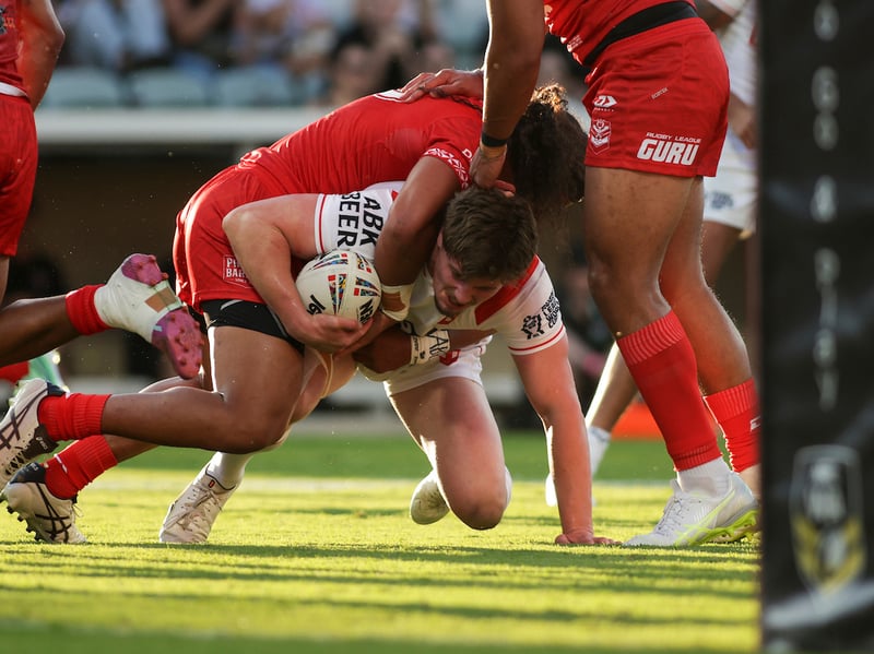 England and Wigan prop Ethan Havard is tackled by Tongan defenders