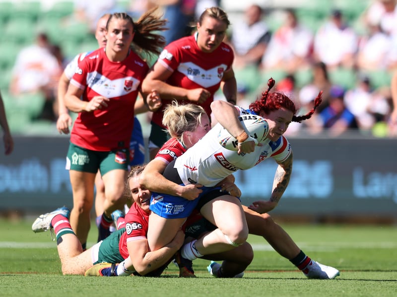 England forward Eva Hunter is brought down by Welsh defenders