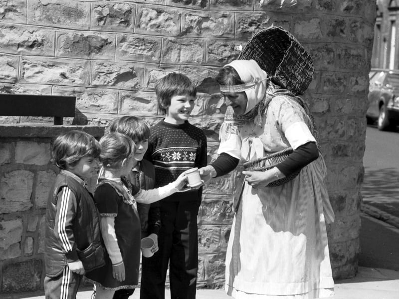 With her basket on her back, traditionally-dressed fishwife Nan Oliver takes her seafood and shellfish round the Trinity area of Edinburgh in May 1982.