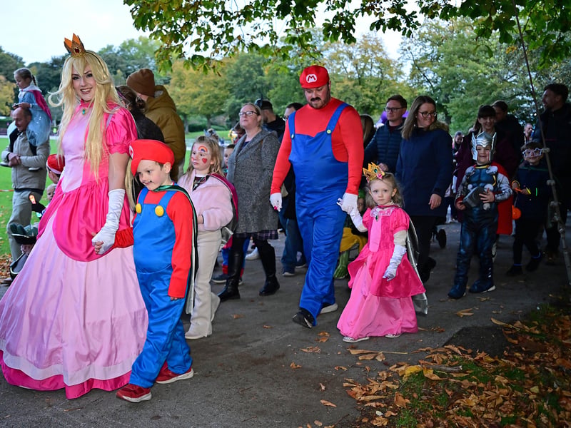 Children and their parents make their way through Queen's Park.
