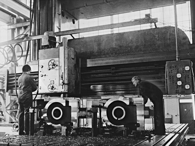 Machinists closely monitor a massive plano-miller at the metal-forming plant division of GKN Machinery, Ltd. in Wolverhampton on October 31, 1970. The skilled engineers are at work on the roll housings of a £160,000 bi-metallic strip mill being manufactured for Vandervell Products. Each large casting for the two-high mill stand required approximately seven hours of rough machining followed by eleven hours in the finishing stage, yielding stands engineered to support a rolling load specification of 300 tons. Do you remember GKN Machinery's sprawling works in Wolverhampton or know anyone who operated these massive industrial tools? What are your memories of the engineering plants that powered the local economy back in 1970?