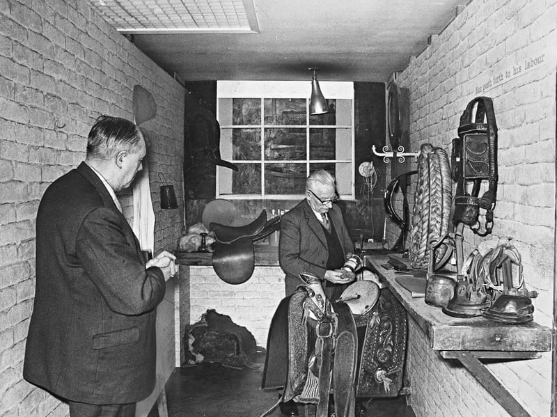 Visitors inspect hand-crafted saddles, ornate bridles, and traditional saddlery tools on display at the Leather Museum exhibition inside Walsall Library on January 15, 1970. Surrounded by exposed brick walls bearing the painted motto "Man goeth forth to his labour", the evocative workshop display celebrated Walsall’s historic reputation as the world-renowned heart of the leather and saddlery trade. The exhibition provided local residents with a fascinating glimpse into the intricate skills and bench work that defined the town’s industrial identity for generations. Do you remember visiting the leather displays or local historical exhibitions at Walsall Library around 1970? Did anyone in your family work in the famous Walsall leather, saddlery, or lorinery trades?