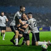 Stephen Walsh is congratulated by Aaron Bolger and Lee Devitt after scoring the equaliser in Waterford on Monday night. 