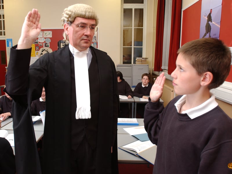 Pictured in June, 2002, 13-year-old Trinity Academy pupil John Spencer is sworn in as a witness by QC Sandy Wylie, who visited the school to teach the children about court procedures.