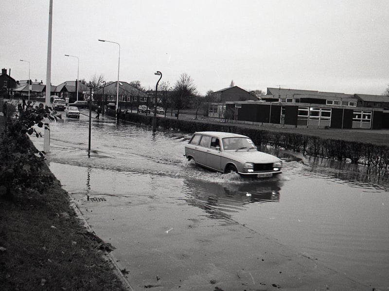 A car attempts to drive through floodwater in Preston in November 1980