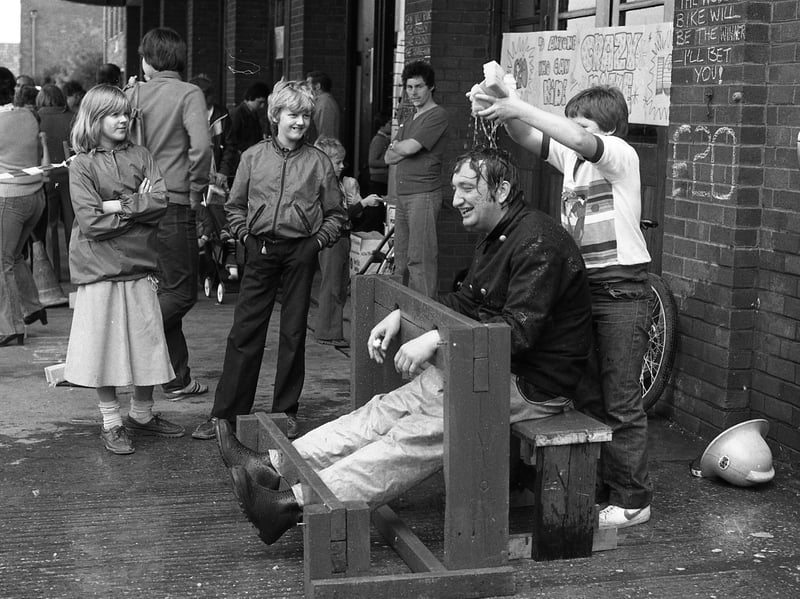 Fireman Kevin O'Shea gets a soaking from the children, in the stocks at Preston Fire Brigade Summer Fair in 1980. It was held to raise money for the Fire Services National Benevolent Fund.