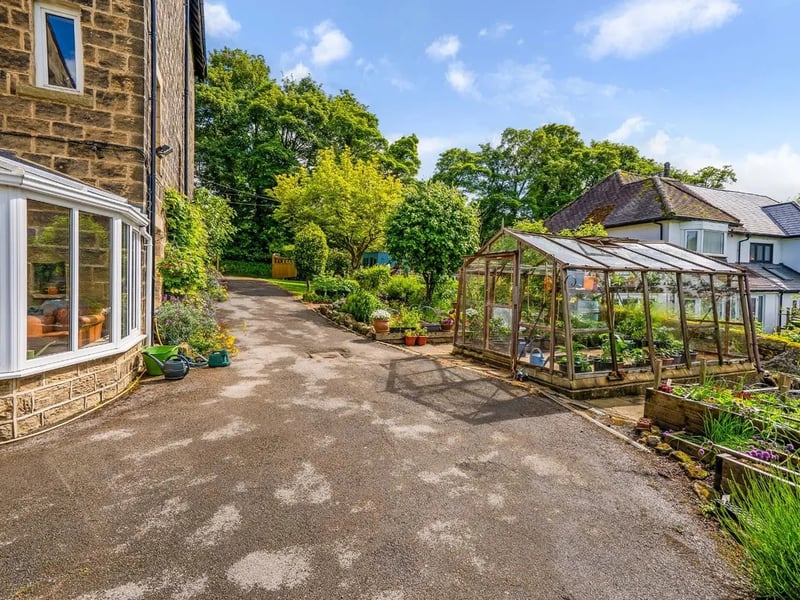 The garden features a decorative greenhouse for all your pottering needs.