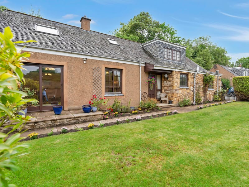The front features a southeast-facing aspect and a generous stretch of lawn framed by colourful plants. Extras: all fitted floor and window coverings, light fittings, integrated appliances (fridge, freezer, and dishwasher), gas range cooker by Rangemaster, and undercounter washing machine to be included in the sale. 