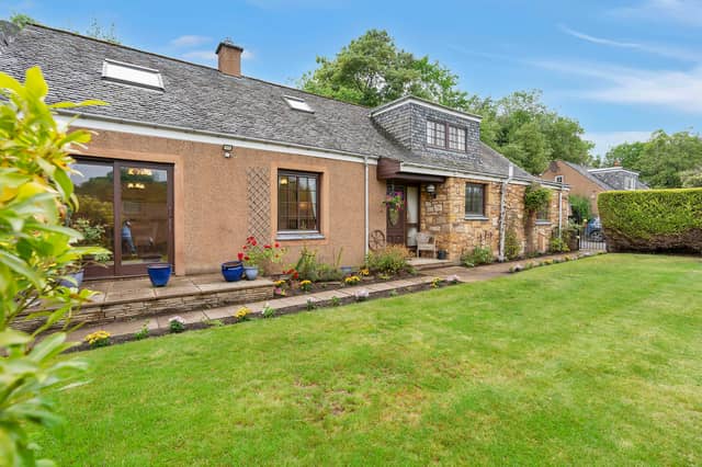 The front features a southeast-facing aspect and a generous stretch of lawn framed by colourful plants. Extras: all fitted floor and window coverings, light fittings, integrated appliances (fridge, freezer, and dishwasher), gas range cooker by Rangemaster, and undercounter washing machine to be included in the sale.