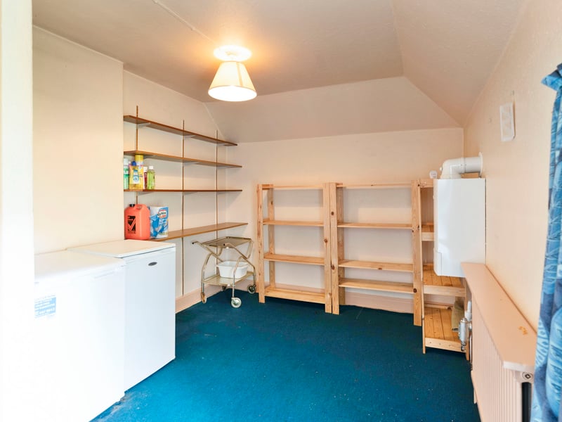 A door opens onto the rear garden, while stairs from the dining room rise to a generous pantry/store above the kitchen.