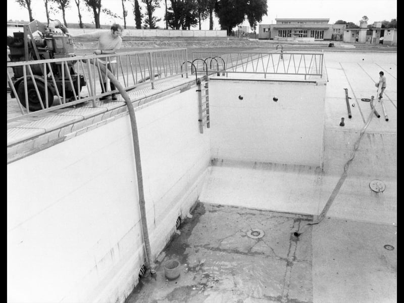 Hilsea Lido pool supervisor Mr N Padmore, left, and at the base of the pool, assistant N Goddard pumping out the dirty rainwater ready for refilling in June 1981.
Picture: (PP1282)