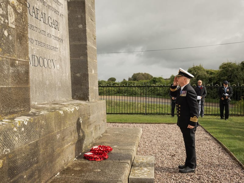 Cdr May salutes the monument.