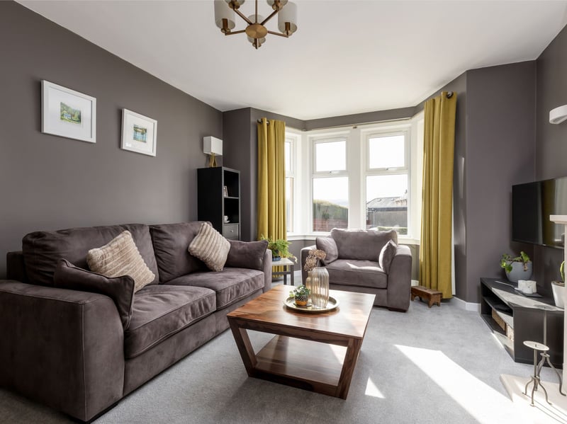 The accommodation begins with a welcoming entrance hallway leading to a charming bay-windowed lounge, featuring a decorative fireplace that creates a warm and inviting focal point, perfect for relaxing on a winter's evening.