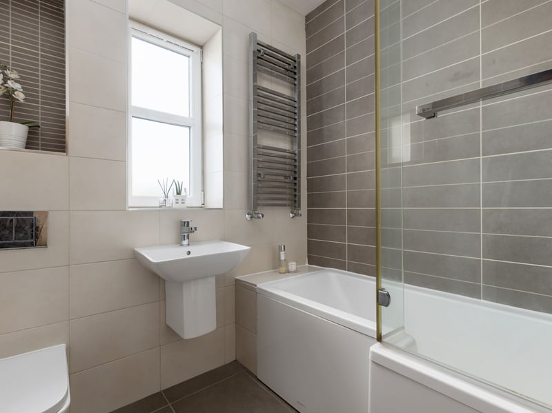 The impressive Corstorphine property's modern family bathroom is fitted with a three-piece suite and mains shower over the bath.