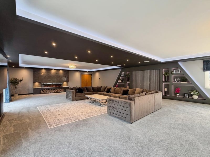 A dedicated cinema wall provides the perfect setting for movie nights, while the impressive bespoke bar and drinks area incorporates display cabinets and an acoustic-panelled feature wall, creating a luxurious environment in which to entertain family and friends.