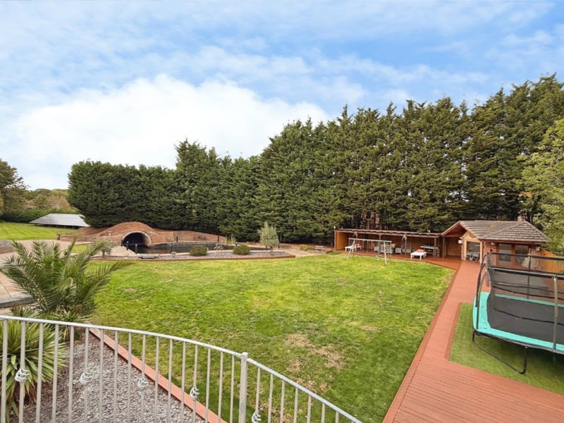 The gardens have been meticulously landscaped and feature a spectacular ornamental pond with its own attractive brick-built bridge, extensive paved patio and entertaining areas, raised decked seating areas and a sunken Jacuzzi hot tub.