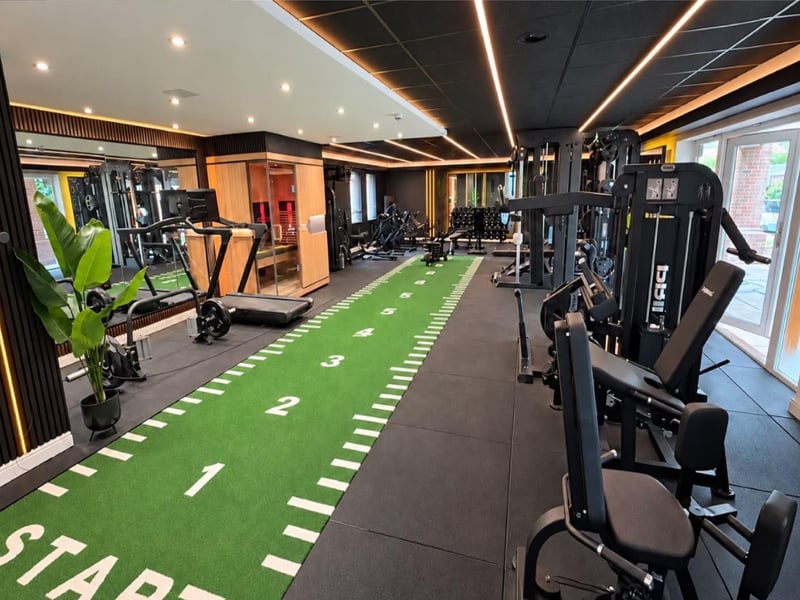 A full-size private gymnasium designed to an exceptional standard, featuring acoustic-panelled walls, sophisticated LED and recessed lighting, integrated music speakers and rear-facing UPVC double-glazed windows.