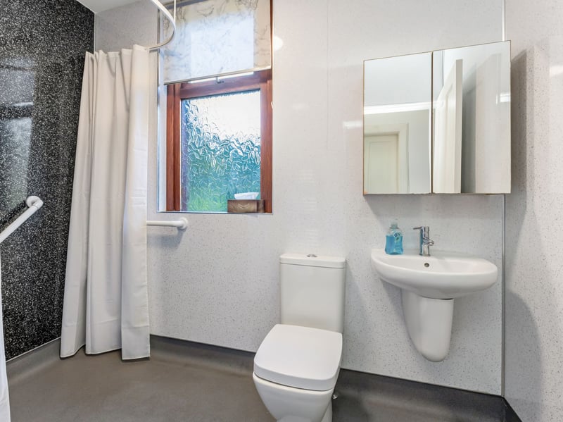 The modern wet room with walk-in shower, wash hand basin and WC.