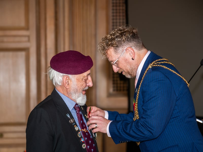  Veteran Neil Munro receiving his poppy from the Lord Mayor of Leeds Stephen Holroyd.