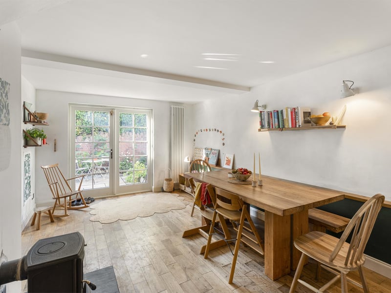 The dining area off the kitchen has its own wood-burning stove, while French doors open directly onto the rear patio garden, making this a welcoming space for everyday living and entertaining.