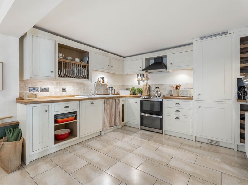 Next door, the generous kitchen and dining room features country-style Shaker cabinetry, a good range of cupboards and a combination of freestanding and integrated appliances.