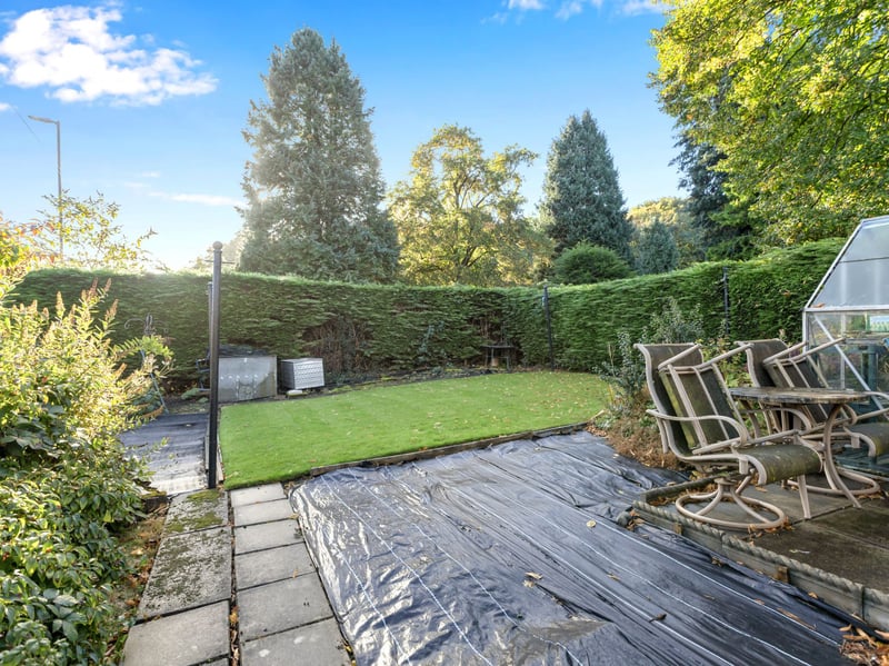 The enclosed garden grounds with lawn, established planting and patio areas. As well as traditional stone boundary walls, decorative iron railings and a small gated driveway providing off-street parking.